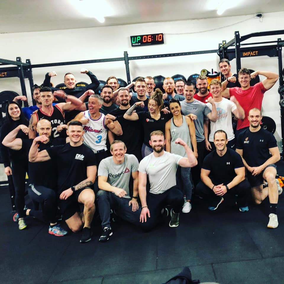 Elite Academy personal training graduates flexing in the gym after completing their course